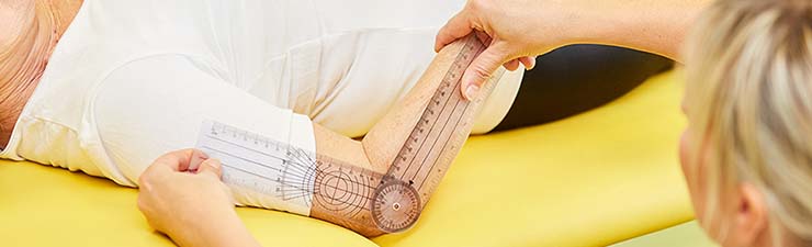 Health care provider using a goniometer to evaluate a patient's elbow
