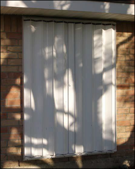 Impact resistant shutter system installed over a window opening.