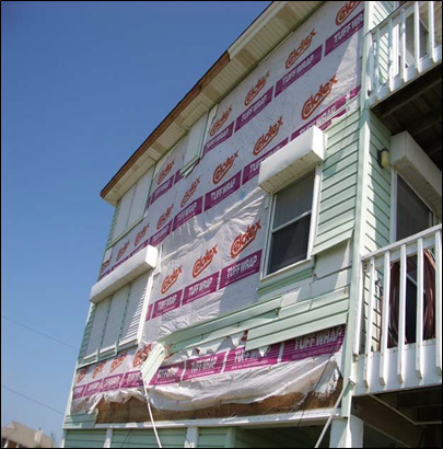 Wall sheathing being checked before exterior siding is installed.