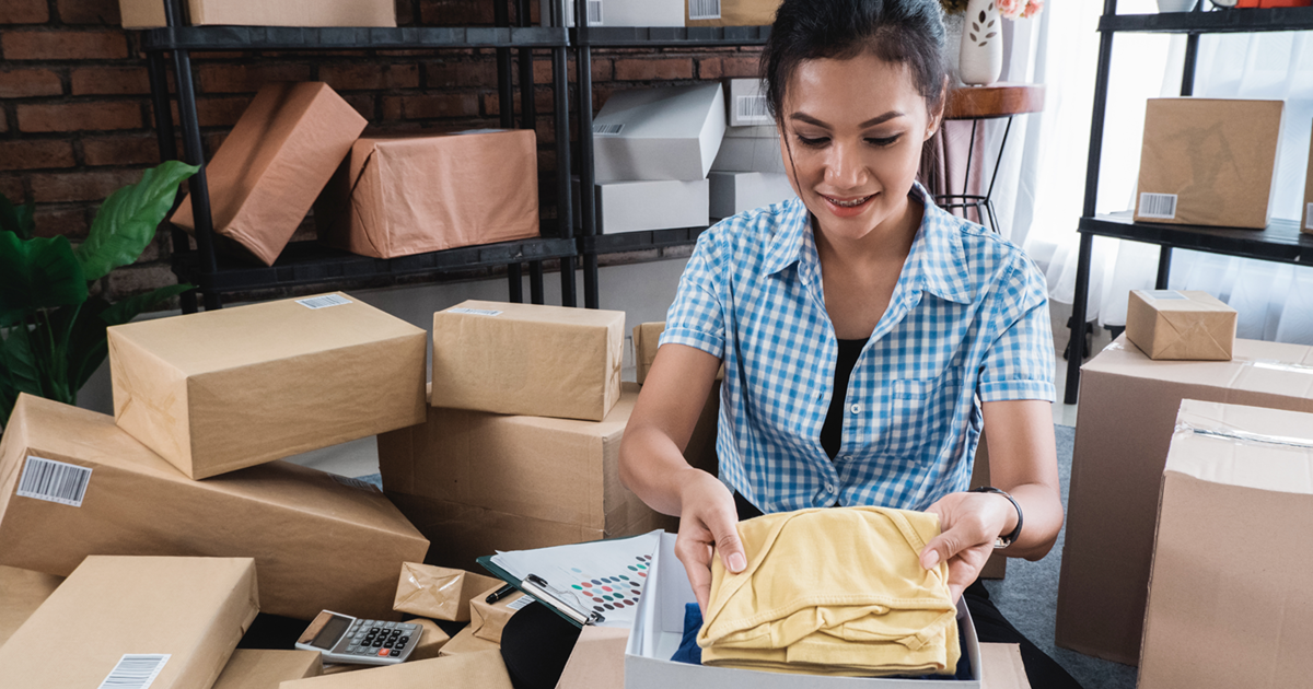 Woman packing merchandise in her living room