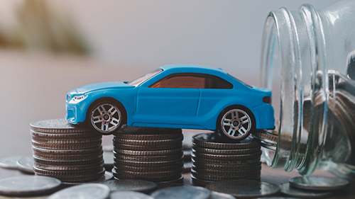 Blue toy car rests on coin stacks