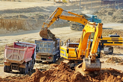 Dump trucks being loaded at a construction site